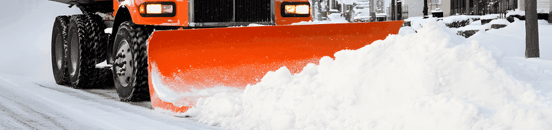 Snow plow truck clearing snow from driveway
